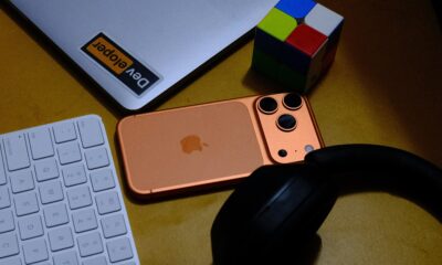 iPhone 17 Pro cosmic orange on desk with laptop keyboard headphones