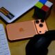 iPhone 17 Pro cosmic orange on desk with laptop keyboard headphones