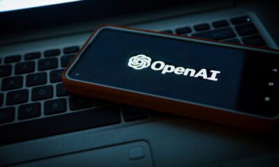 smartphone on laptop keyboard showing OpenAI logo