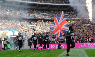 NFL players running onto a field with union jack flag