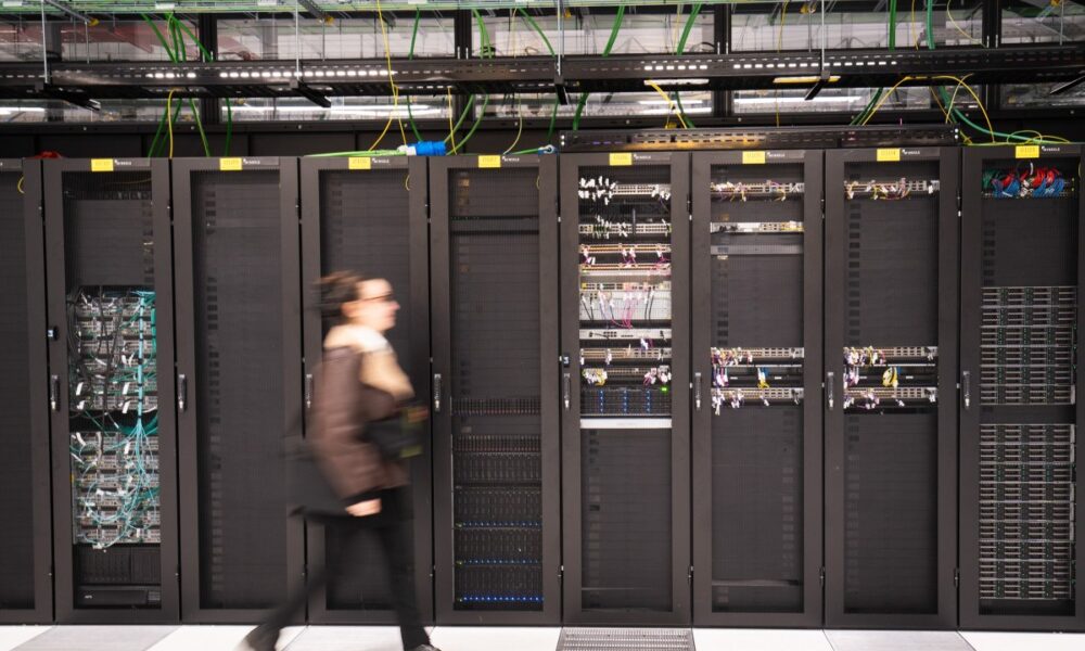 A visitor walks past a computer bay at the PA10 data center, operated by Equinix Inc., in Paris, France.