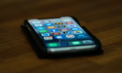 iPhone on table with apps home screen blurred