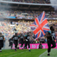 NFL players running onto a field with union jack flag