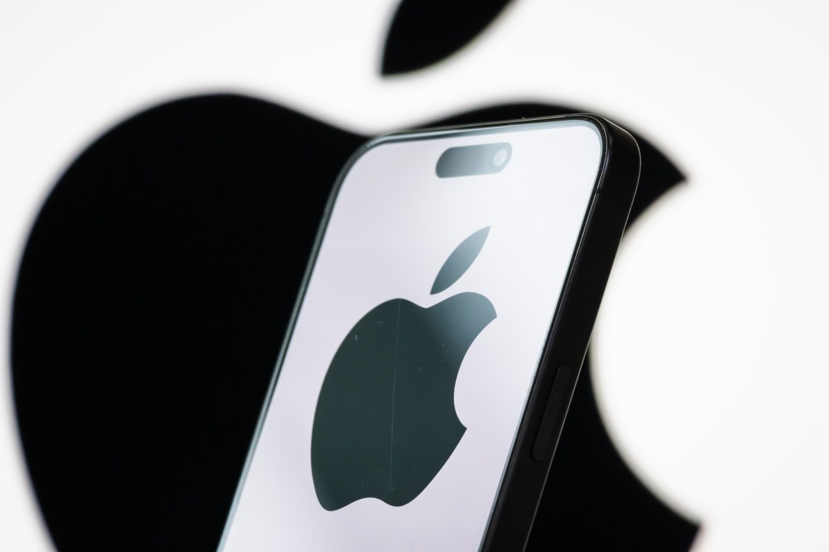 In this photo illustration, the logo of Apple Inc. is displayed on a smartphone screen, with the company's iconic black apple symbol visible in the background.