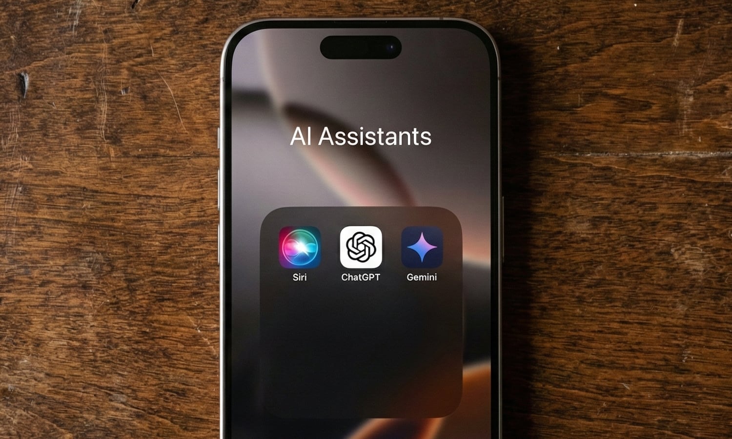 Overhead shot of an iPhone lying face-up on a textured brown wooden surface. The screen shows an open iOS folder titled "AI Assistants" featuring the colorful Siri orb icon, the ChatGPT logo, and the Gemini star icon.