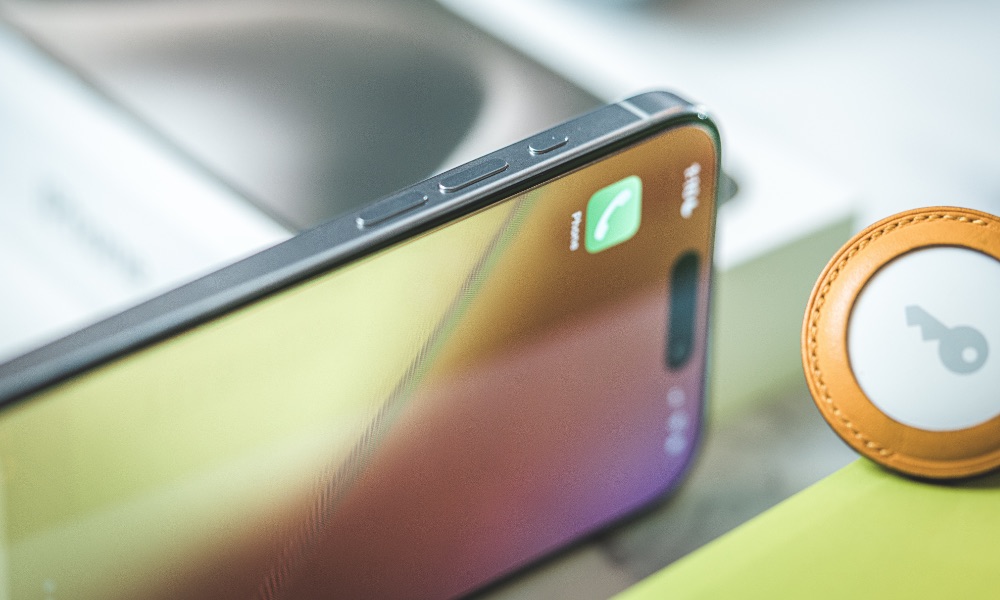 iPhone 15 Pro on side with AirTag