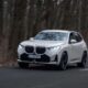 2026 BMW X3 xDrive30e plug-in hybrid SUV driving on a winding road
