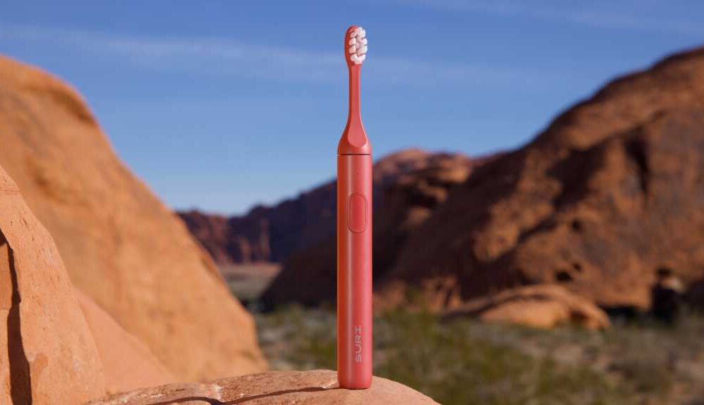 Suri 2.0 Canyon Sunrise electric toothbrush standing on a rock