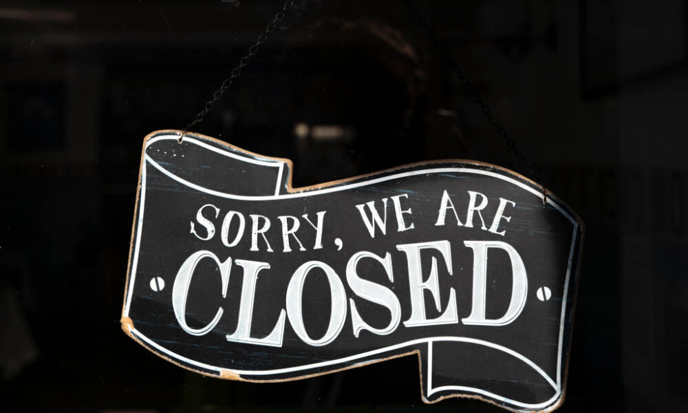 A closed sign in the window of a small business