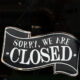 A closed sign in the window of a small business