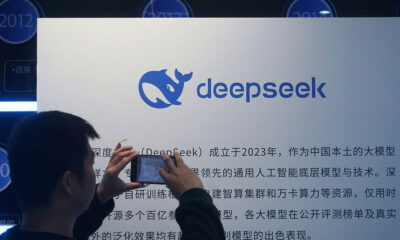 A man takes photos of a DeepSeek display at a shopping mall in Hangzhou