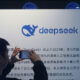 A man takes photos of a DeepSeek display at a shopping mall in Hangzhou