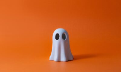 Cute Halloween Ghost over orange background.