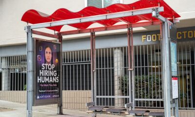 Bus stop shelter with red canopy and ad for Artisan AI reading "Stop Hiring Humans" and "For Work They Hate" on city sidewalk, San Francisco, California, September 30, 2025. (Photo by Smith Collection/Gado/Getty Images)