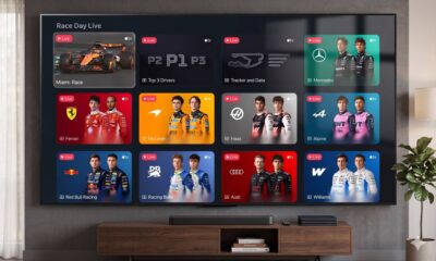 A flat-screen TV displaying the F1 "Race Day Live" multiview feed on the Apple TV app, positioned above a media console in a modern, well-lit living room setting.