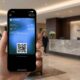 Hand holding an iPhone 17 Pro Max displaying a custom club membership pass with a QR code in the Apple Wallet app on iOS 27 beta.