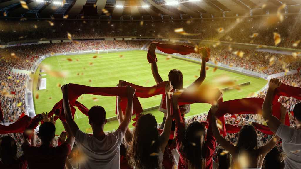 Fans holding up their flags at a football stadium