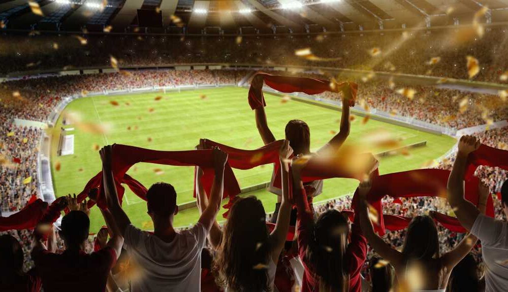 Fans holding up their flags at a football stadium