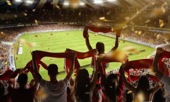 Fans holding up their flags at a football stadium