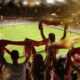 Fans holding up their flags at a football stadium