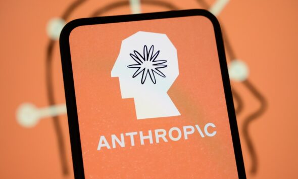 The Anthropic logo is displayed on the screen of a smartphone with the company's branding in the background.