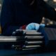 A person handles a nuclear fuel assembly.
