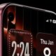 A concept render of the iPhone 18 Pro featuring a top-left hole-punch front camera on a home screen running iOS 26 with the Liquid Glass design aesthetic.