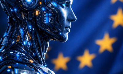 Futuristic humanoid AI figure made of glowing circuit boards and digital technology, shown in side profile against a blurred European Union flag background with golden stars. Advanced artificial intelligence concept, blue cybernetic body with illuminated microchips and data patterns, cinematic lighting, shallow depth of field, ultra-realistic style, high-tech atmosphere, futuristic European AI regulation and digital innovation theme, photorealistic details, dark blue color palette, sharp focus, 8K.