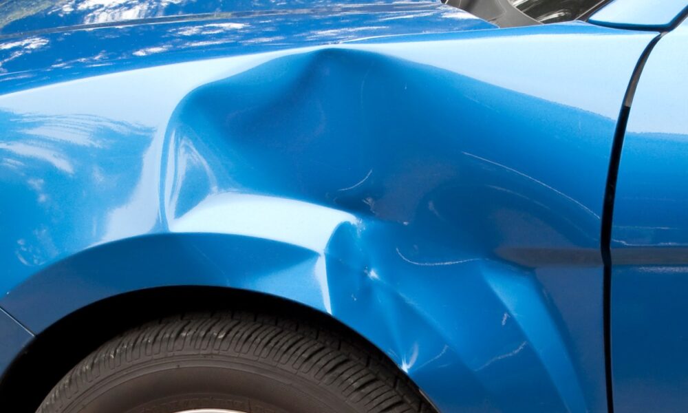 Auto accident leaving a huge dent in the left front quarter panel.
