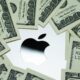 Apple company logo seen on Macbook M1 laptop surrounded by US dollar banknotes. Concept. Selective focus. United Kingdom, Stafford, December 18, 2021.