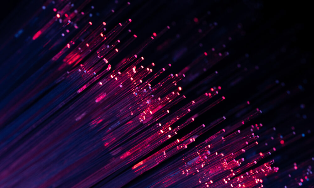 Deployed underground: How Lisbon’s LUMIRing is emerging as a globally recognised testbed for multicore fibre technology Abstract purple and blue fiber optic lights creating a vibrant digital data flow concept, ideal for modern technology and futuristic communication visuals.