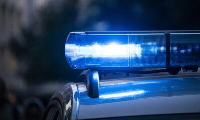 Selective focus of flashing blue police lights on a vehicle roof with a soft bokeh city background.