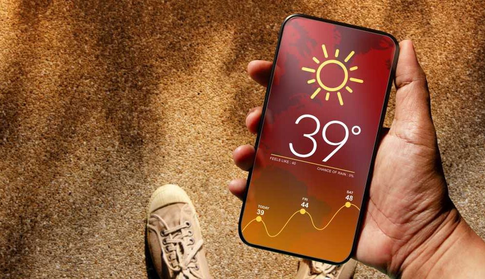 Someone using a smartphone displaying hot weather