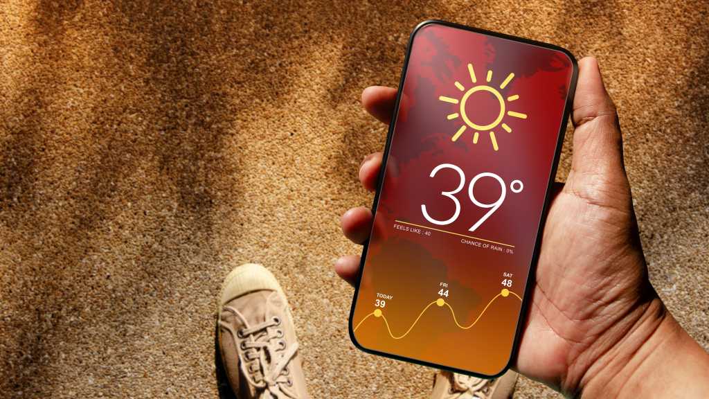 Someone using a smartphone displaying hot weather