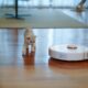 robot vacuum in living room with kittens