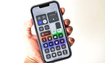 Control center in hand holding iphone 13 isolated on white background