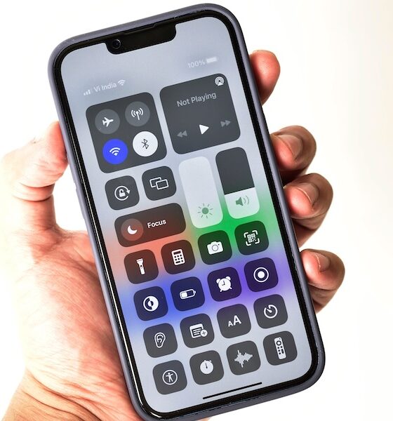 Control center in hand holding iphone 13 isolated on white background