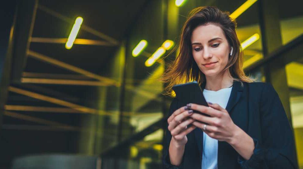 Business Frau mit Smartphone und Ohrhörern