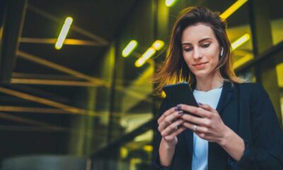 Business Frau mit Smartphone und Ohrhörern