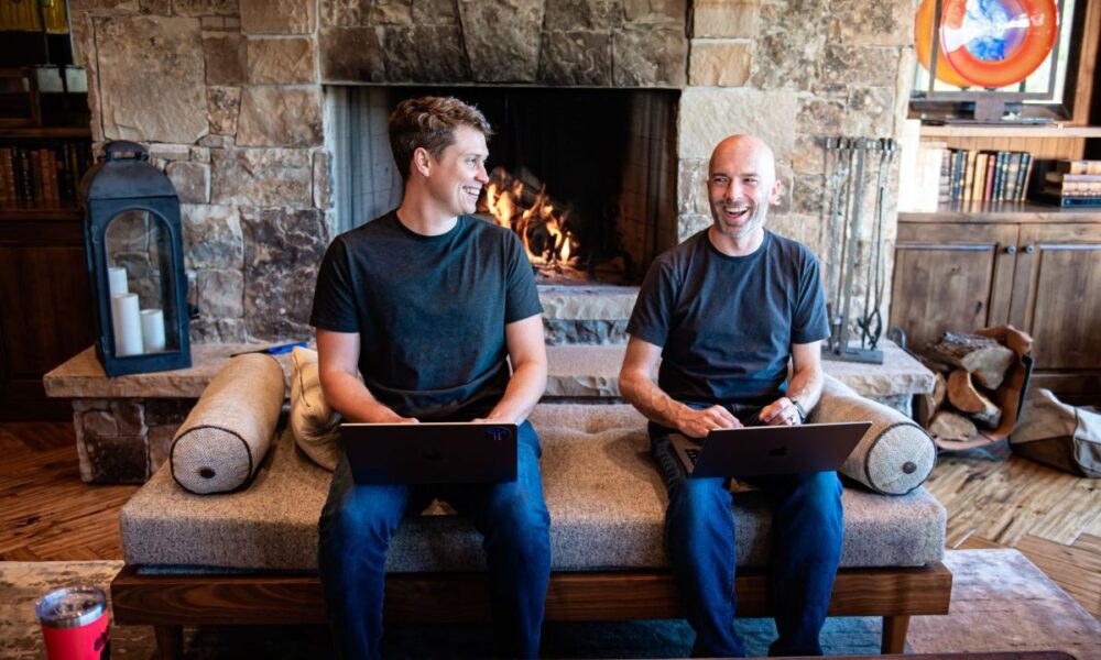 Thatch founders sitting on couch in front of fireplace