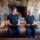 Thatch founders sitting on couch in front of fireplace