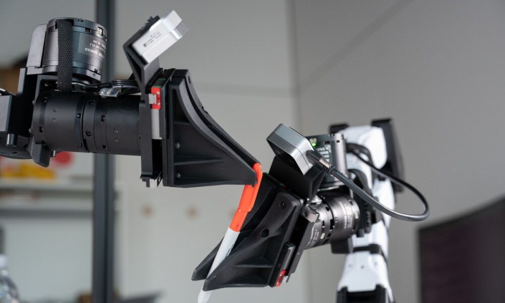 XDOF's robotic arms manipulate a pen and cap.