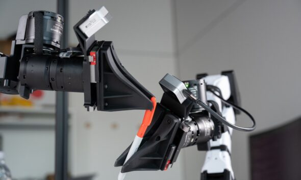 XDOF's robotic arms manipulate a pen and cap.