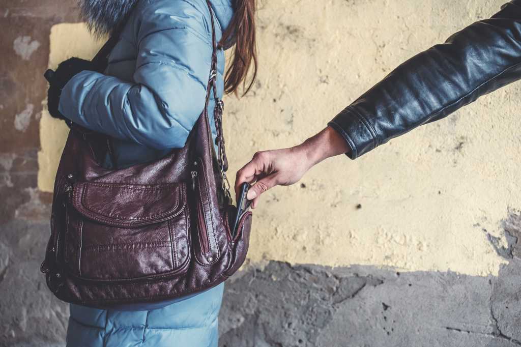 Dieb stiehlt Telefon oder Smartphone aus einer Tasche