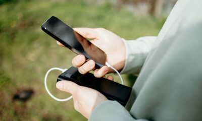 person holding iPhone and battery pack