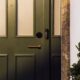 Smart Deadbolt Lock and Video Doorbell are featured on a dark green front door.