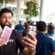 A customer takes a selfie while holding two iPhone 18 Pro boxes at Apple BKC in Mumbai.