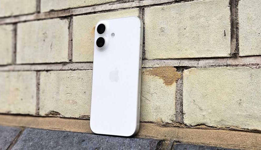 iPhone 17 in white, against a brick wall