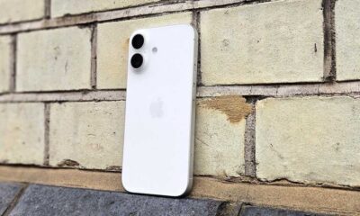 iPhone 17 in white, against a brick wall