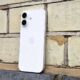 iPhone 17 in white, against a brick wall